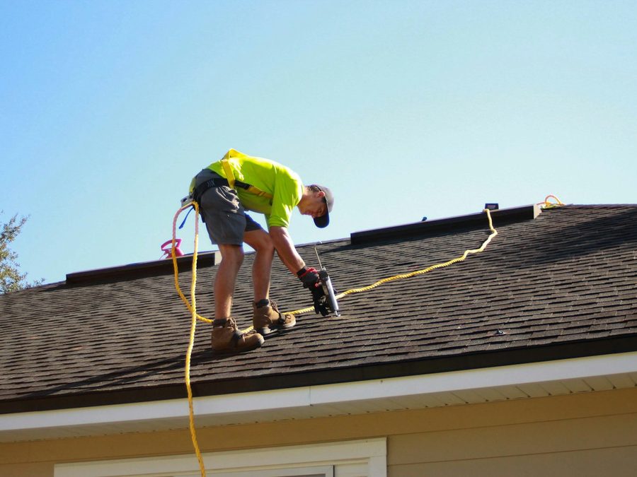A roofer nails down shingles on a pitched roof. Hail accounts for roughly half of a Front Range homeowners premium.