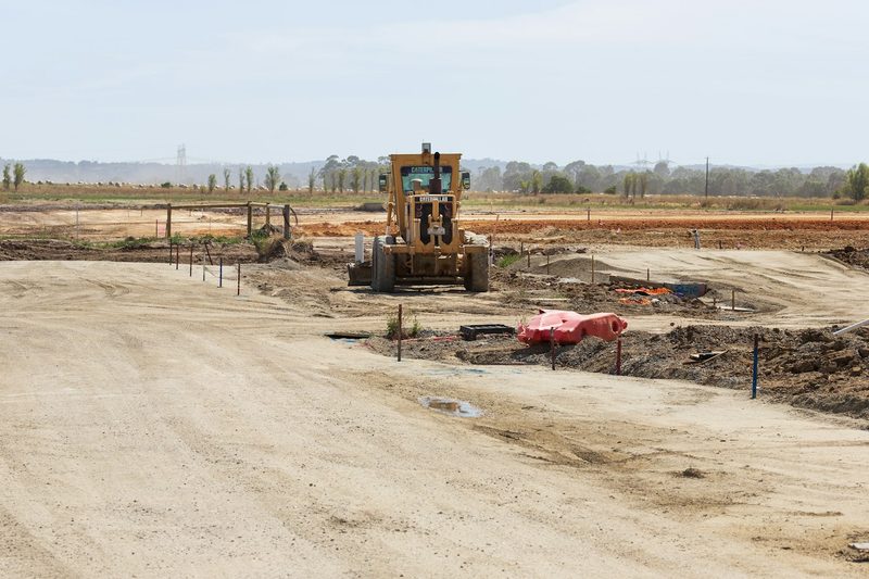 A motor grader levels ground for a new subdivision.